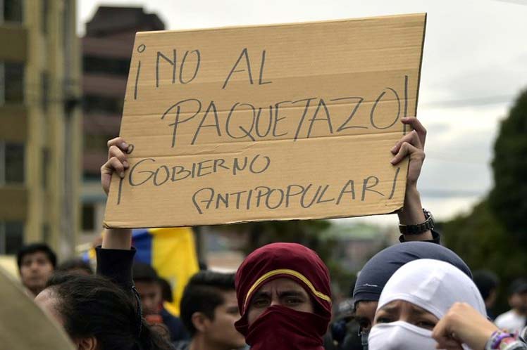 Em manifestação no Equador, manifestante segura cartaz onde se lê "No al paquetazo! Gobierno Antipopular!"