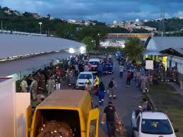 Fotografia com dezenas de trabalhadores na entrada da Regap.