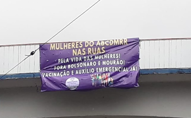 Faixa presa em passarela onde se lê "Mulheres do ABCDMRR nas ruas. Pela vida das mulheres! Fora Bolsonaro e Mourão! Vacinação e Auxílio Emergencial Já!