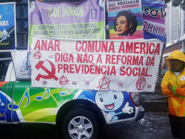 Faixa com os símbolos do anarquismo e do comunismo onde se lê "Diga não à reforma da previdência social"