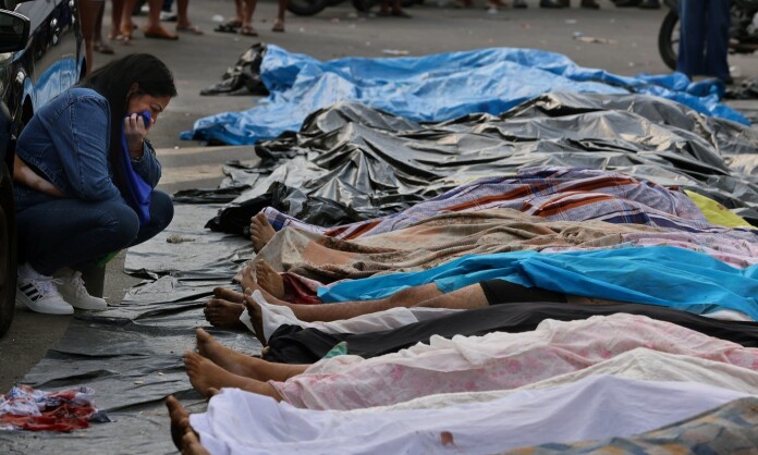 Fotografias com corpos de pessoas pretas e pardas mortas estendidas enfileiradas no chão. Uma mulher agachada chora enquanto olha para uma das vítimas.