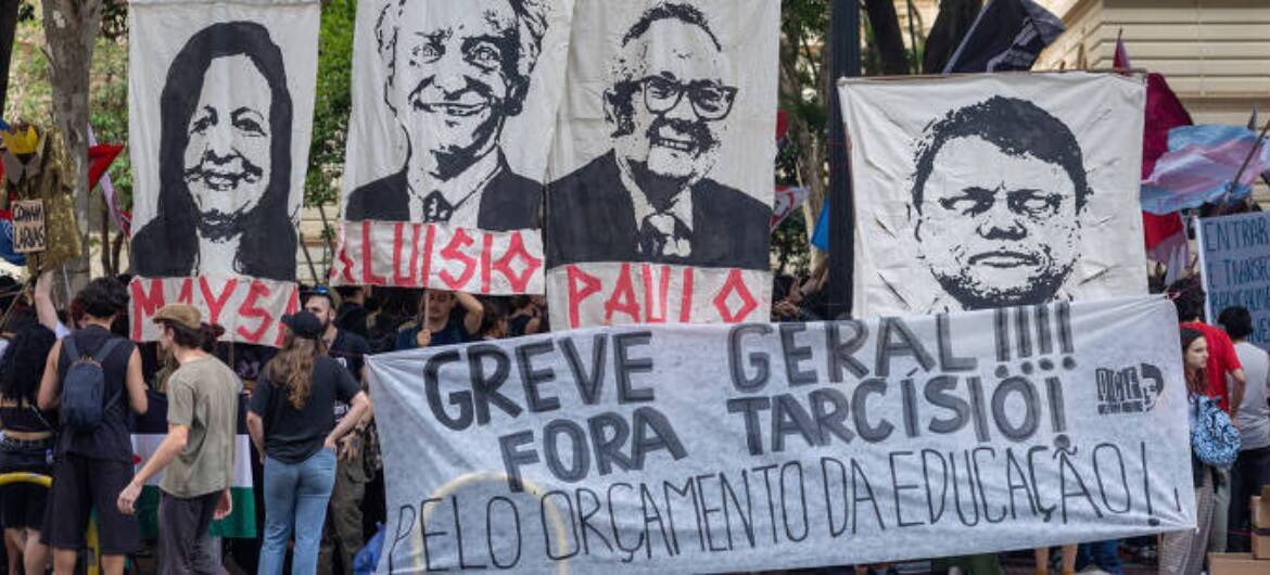 Manifestação da USP em 2026, com cartazes com fotos e nomes de Maysa, Luisio, Paulo e o governador de São Paulo Tarcísio de Freitas e uma faixa na qual está escrito "Greve Geral!!!! Fora Tarcísio! Pelo Orçamento da Educação!"