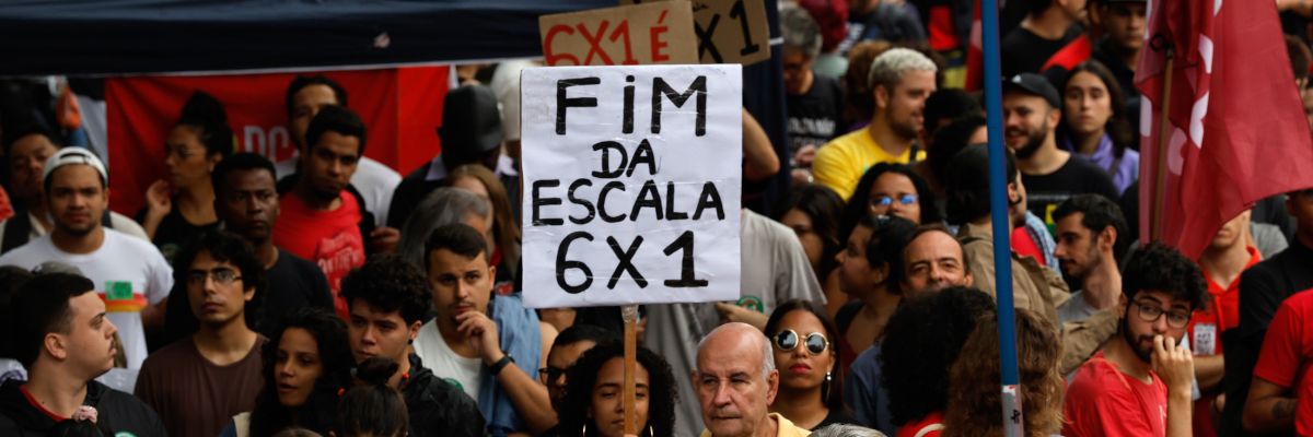 Fotografia de manifestação, na qual um cartaz levantado tem os seguintes dizerem: "Fim da escala 6x1"